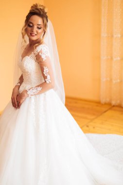 Beyaz elbiseli gelin düğün törenine hazırlanırken poz veriyor..