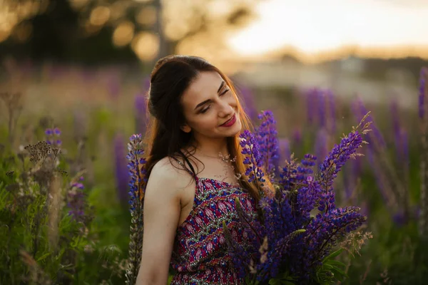 開花フィールドに紫色のラピンで大きな花を保持する若い美しい女の子 総状花序を咲かせます — ストック写真