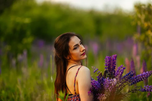 outdoor portrait of a beautiful young age brunette. attractive sexy girl in a field with flowers.