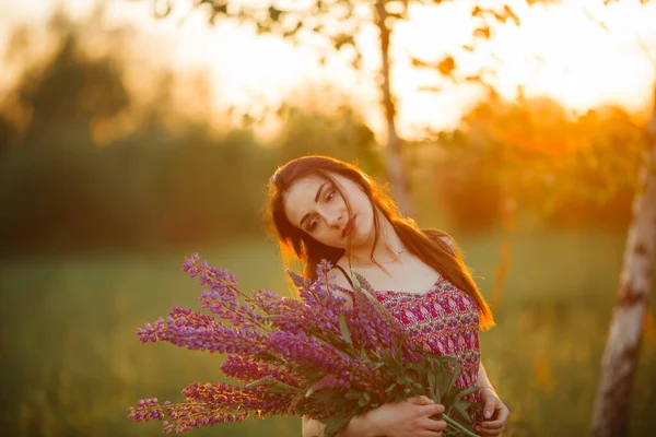 ラベンダー畑を見下ろす畑に立つ少女 笑顔気楽なCaucasian女の子でドレスでザ 夕日を楽しんで — ストック写真