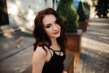 Esmer kadın, Lviv sokaklarında uzun ve güzel bir elbiseyle yürüyor..