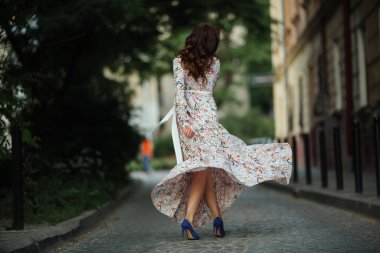 İlkbaharda sokakta yürüyen güzel bir kız. Bahar havasının tadını çıkaran genç bir kadın