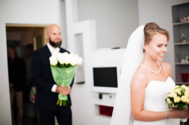 Bunun olduğuna inanamıyorum. Erkek arkadaşı ona yatak odasında evlenme teklif ederken yüzü elle örtülen ve gülümseyen genç bir kadın..