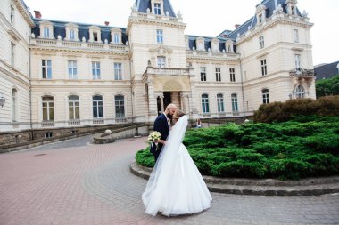 Muhteşem bir düğün çifti, eski şehirde mimari ile güneşli bir günün tadını çıkarıyor..