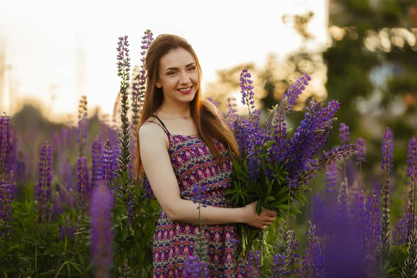 夕暮れ時に畑にいた若い女性 花を持つ — ストック写真