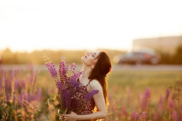 girl in a colored dress. Holds flowers in her hands.