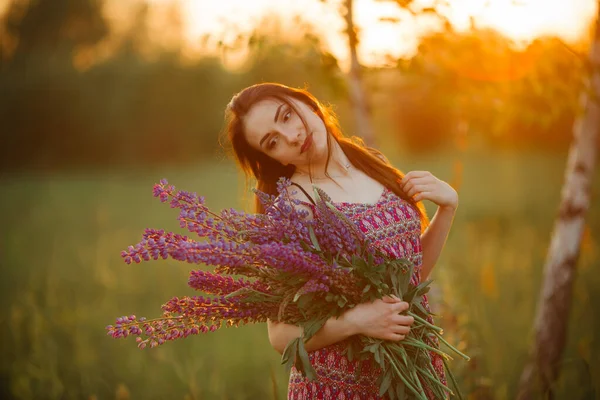 outdoor portrait of a beautiful young age brunette. attractive sexy girl in a field with flowers.