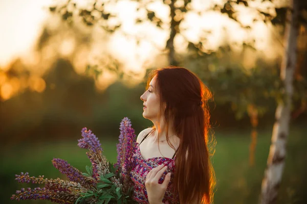 夕暮れ時に畑にいた若い女性 花を持つ — ストック写真