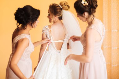 Beyaz elbiseli gelin düğün törenine hazırlanırken poz veriyor..