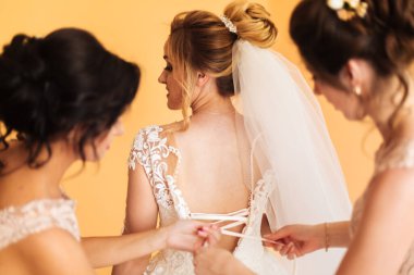 Beyaz elbiseli gelin düğün törenine hazırlanırken poz veriyor..