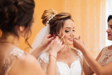 Gelinin kız arkadaşı gelini düğün gününe hazırlar. Gelinin kız arkadaşı törenden önce gelinin gelinliğinin güvenliğini sağlar..