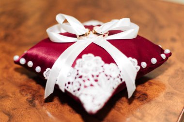 Evlilik yüzükleri. Kırmızı bir yastığa uzan..