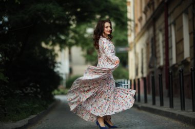 Esmer, Lviv sokaklarında güzel, uzun bir elbiseyle dans ediyor..