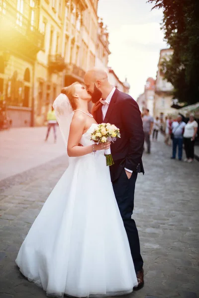 Muhteşem bir düğün çifti, eski şehirde mimari ile güneşli bir günün tadını çıkarıyor..