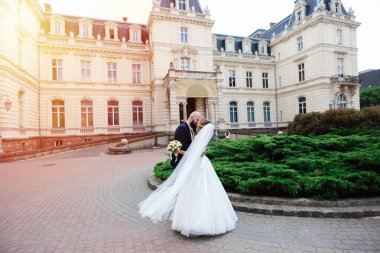 Muhteşem bir düğün çifti, eski şehirde mimari ile güneşli bir günün tadını çıkarıyor..