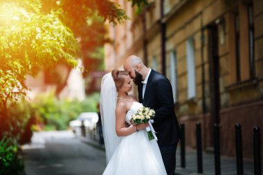 Muhteşem bir düğün çifti, eski şehirde mimari ile güneşli bir günün tadını çıkarıyor..