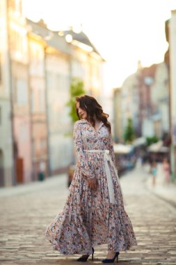 İlkbaharda sokakta yürüyen güzel bir kız. Bahar havasının tadını çıkaran genç bir kadın