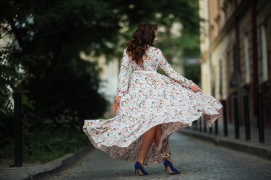 Esmer, Lviv sokaklarında güzel, uzun bir elbiseyle dans ediyor..
