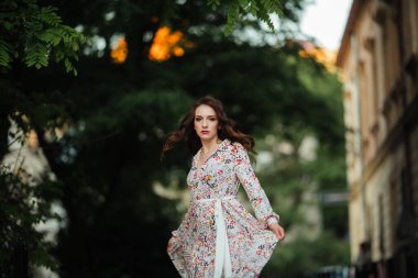 Esmer kadın, Lviv sokaklarında uzun ve güzel bir elbiseyle yürüyor..