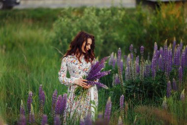 Çiçek tarlasında, güzel elbiseli bir kız..