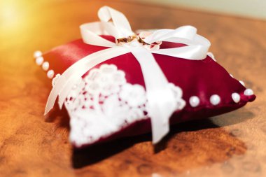 Evlilik yüzükleri. Kırmızı bir yastığa uzan..