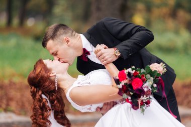 Genç, güzel esmer gelin ve dışarıda poz veren yakışıklı damadın yakın çekimi..