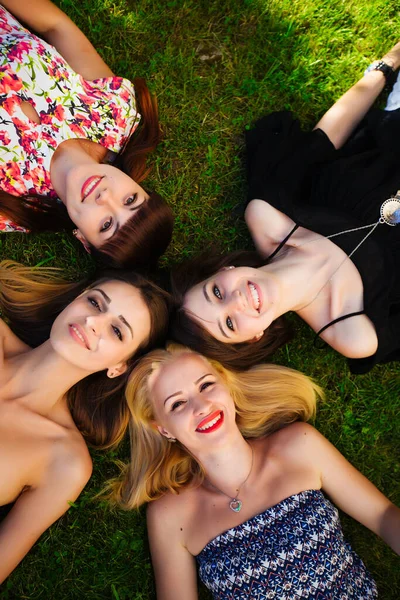 공원의 배경에서 포즈를 취하고 있는 네 명의 아름다운 소녀 — 스톡 사진