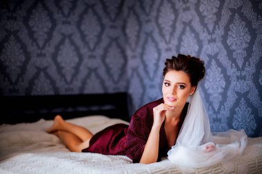 Düğün sabahı yatakta poz veren güzel gelinin portresi.