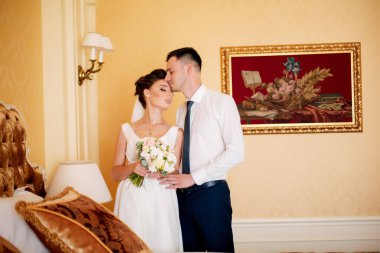 Şık, lüks bir gelin ve yakışıklı, zarif bir damat eski binanın arka planında muhteşem bir pencerede el ele tutuşuyorlar..