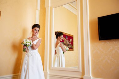 Uzun elbiseli şirin bir gelin. Otelde moda gelin güzelliği. Güzel gelinin portresi. Düğün fotoğrafçılığı