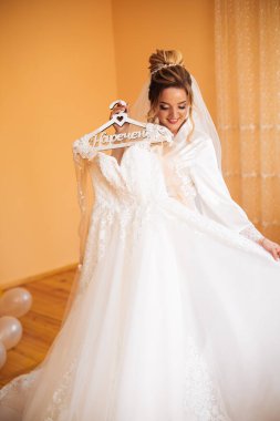 Beyaz elbiseli gelin düğün törenine hazırlanırken poz veriyor..