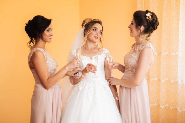婚礼上 新娘和快乐的女朋友们用杯子喝香槟 新娘和女朋友在房间里拥抱 晨曦新娘和女朋友 — 图库照片