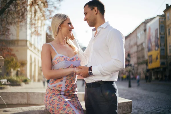 Jong paar in liefde knuffelen elkaar op stad achtergrond — Stockfoto