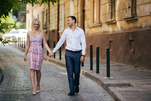 Samen door de straat lopen. Gelukkige jongeman en lachende vrouw wandelen door de straten van de oude stad, — Stockfoto