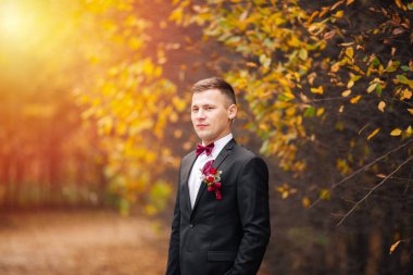 Baharın bahçesindeki ağaçların arasında duran mutlu nişanlı..