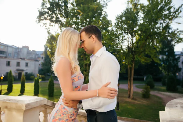 Jong paar in liefde knuffelen elkaar op stad achtergrond — Stockfoto