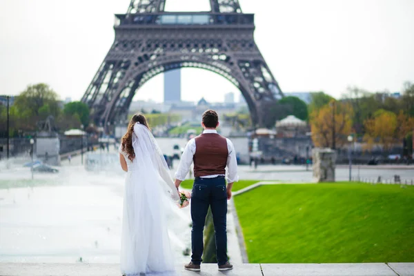 Noiva e noivo tendo um momento romântico no dia do casamento em Paris, em frente ao tour Eiffel — Fotografia de Stock