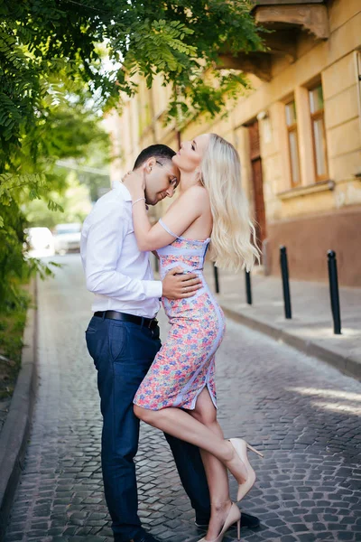 Mladý pár v lásce objetí navzájem na pozadí města — Stock fotografie
