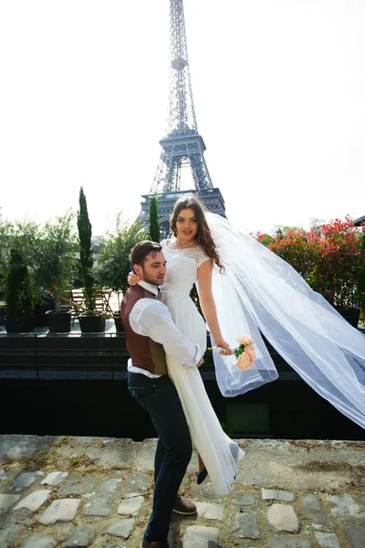 Bride and groom having a romantic moment on their wedding day in Paris, in front of the Eiffel tour