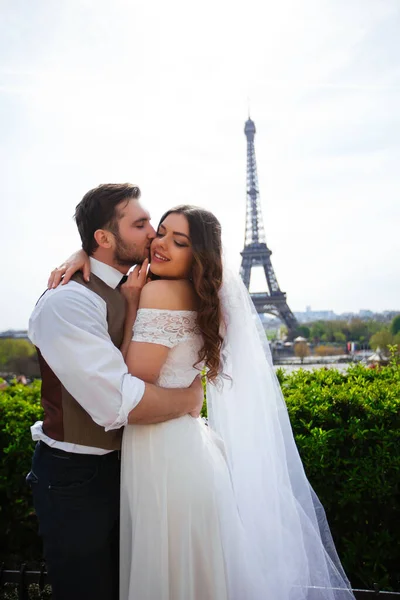 Bride and groom having a romantic moment on their wedding day in Paris, in front of the Eiffel tour — Stock Photo, Image