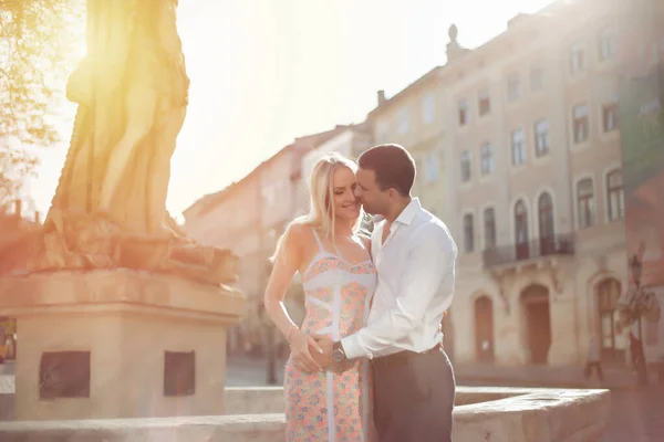 Mladý pár v lásce objetí navzájem na pozadí města — Stock fotografie