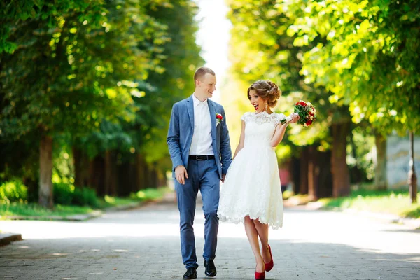 Couple de mariage, jeunes mariés heureux et mari étreignant dans le parc vert . — Photo