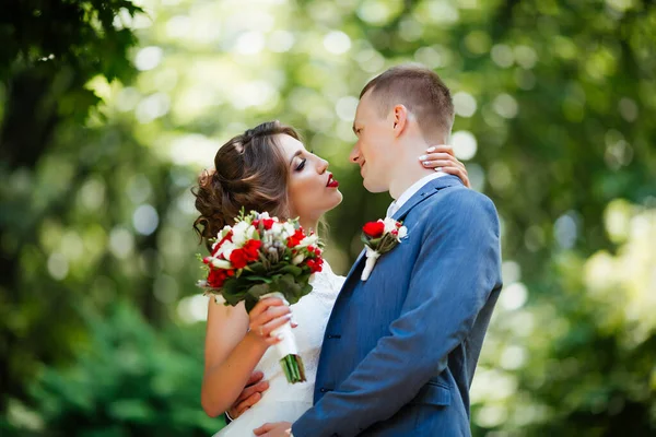 Bröllopspar, glada nygifta och make kramas i grön park. — Stockfoto
