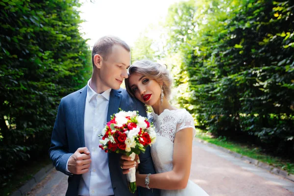 Couple de mariage, jeunes mariés heureux et mari étreignant dans le parc vert . — Photo