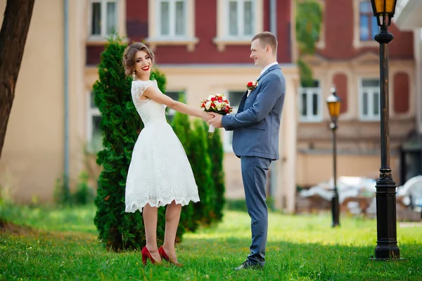 結婚式のカップル幸せな新婚夫婦と夫は緑の公園で抱き合って. — ストック写真