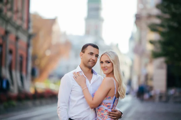 Marchant dans la rue ensemble. Un jeune homme heureux et une femme souriante marchant dans les rues de la vieille ville, — Photo