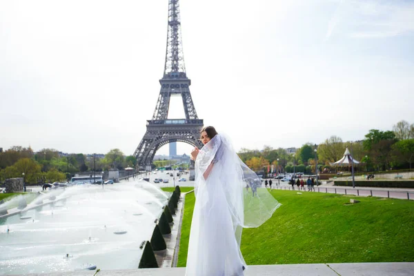Gyönyörű menyasszony gazdag esküvői ruha örvénylik a téren, mielőtt az Eiffel-torony — Stock Fotó