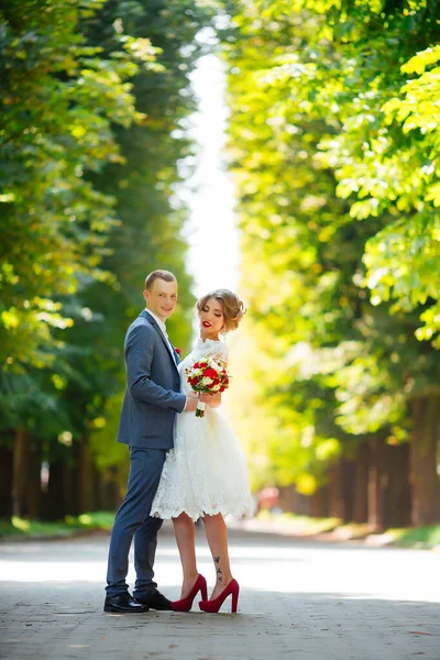 結婚式の日に花嫁と新郎は、自然の中で屋外を歩く. — ストック写真