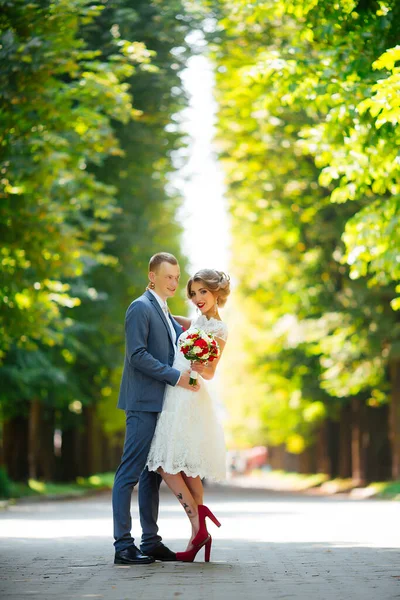 Elegante Braut und Bräutigam posieren zusammen im Freien an einem Hochzeitstag — Stockfoto
