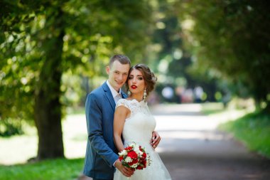 Güneşli bir günde parkta poz veren harika genç bir çift..